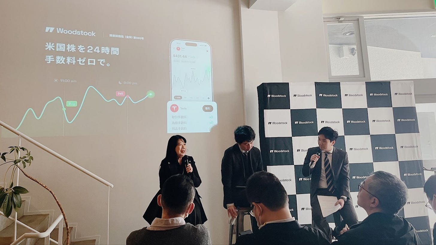 Woodstock主催の投資イベントで行われたパネルディスカッション。米国株24時間取引と手数料ゼロを紹介するスライドを背景に登壇者が対談している。 Woodstock主催の投資イベントで行われたパネルディスカッション。米国株24時間取引と手数料ゼロを紹介するスライドを背景に登壇者が対談している。