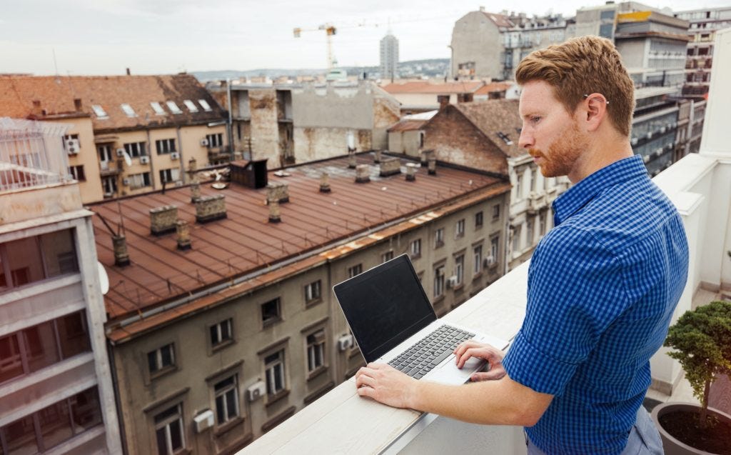 Business person using laptop on rooftop Business person using laptop on rooftop