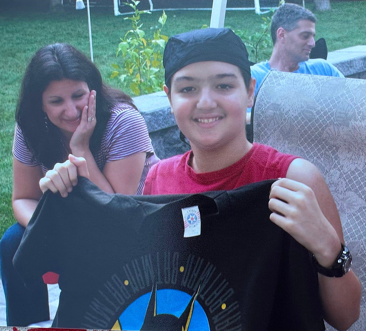 teen wearing a headband and holding a batman t-shirt