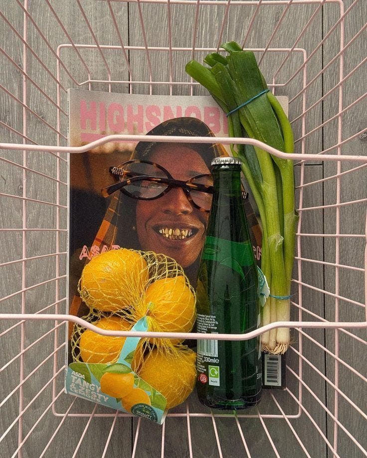 This may contain: a pink shopping cart with an advertisement on the side and vegetables in front of it