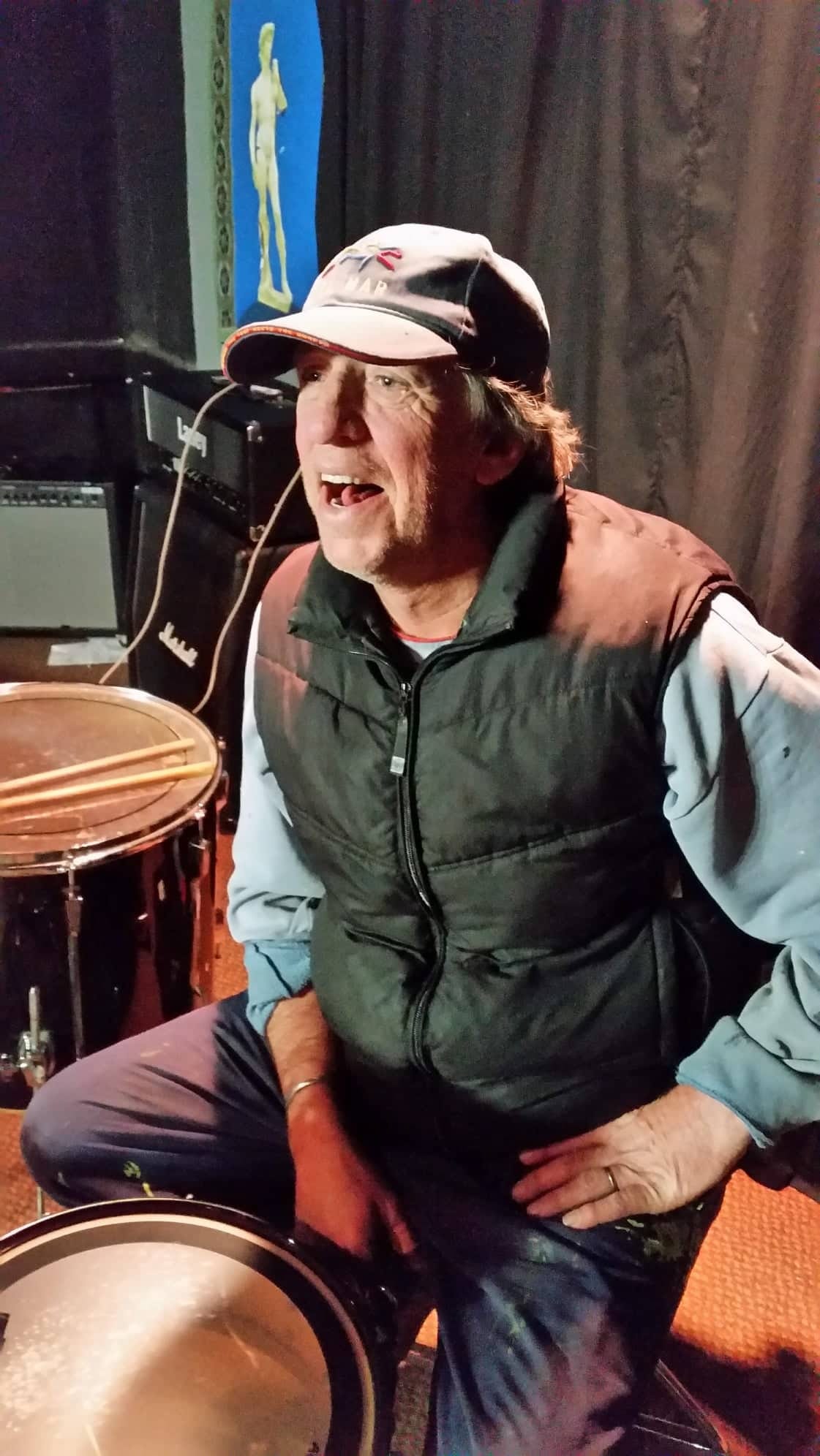 Photograph of a man sitting behind a drum kit