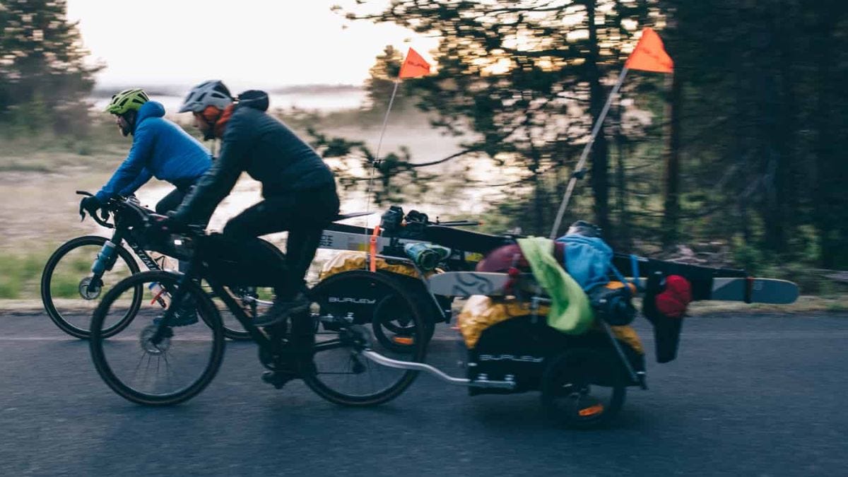 two men bike with ski trailers attached to their bikes two men bike with ski trailers attached to their bikes