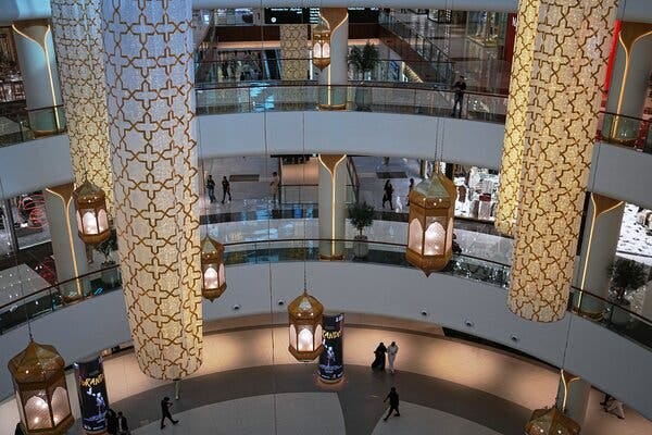 An overhead shot of a multilevel shopping mall, with elaborate gold lighting. An overhead shot of a multilevel shopping mall, with elaborate gold lighting.