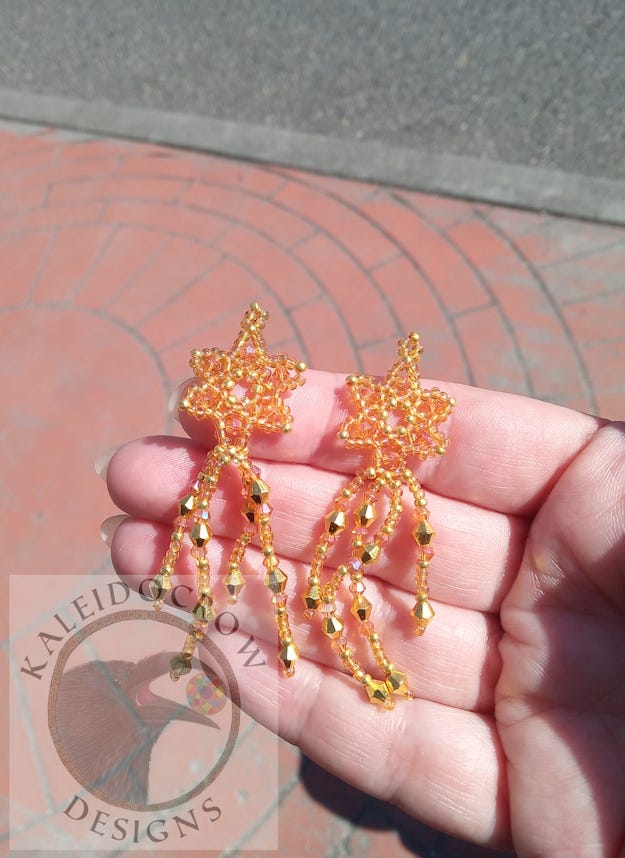 Sparkly dangly beaded earrings in a peach/gold color and a green/gold color.