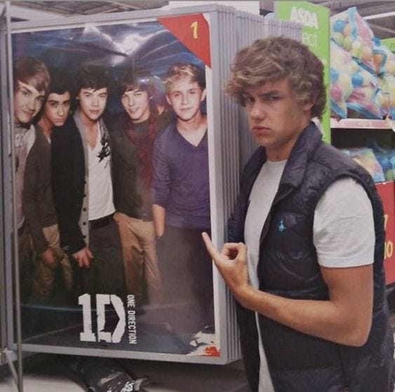 This may contain: a young man standing in front of a poster