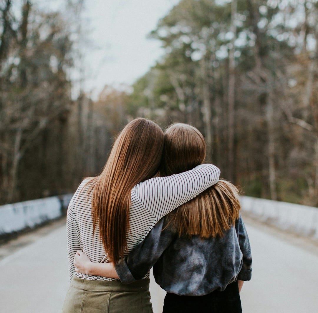 woman in black jacket standing on road during daytime woman in black jacket standing on road during daytime
