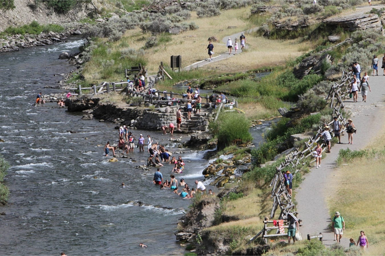 overhead view of visitors swimming and wading in river