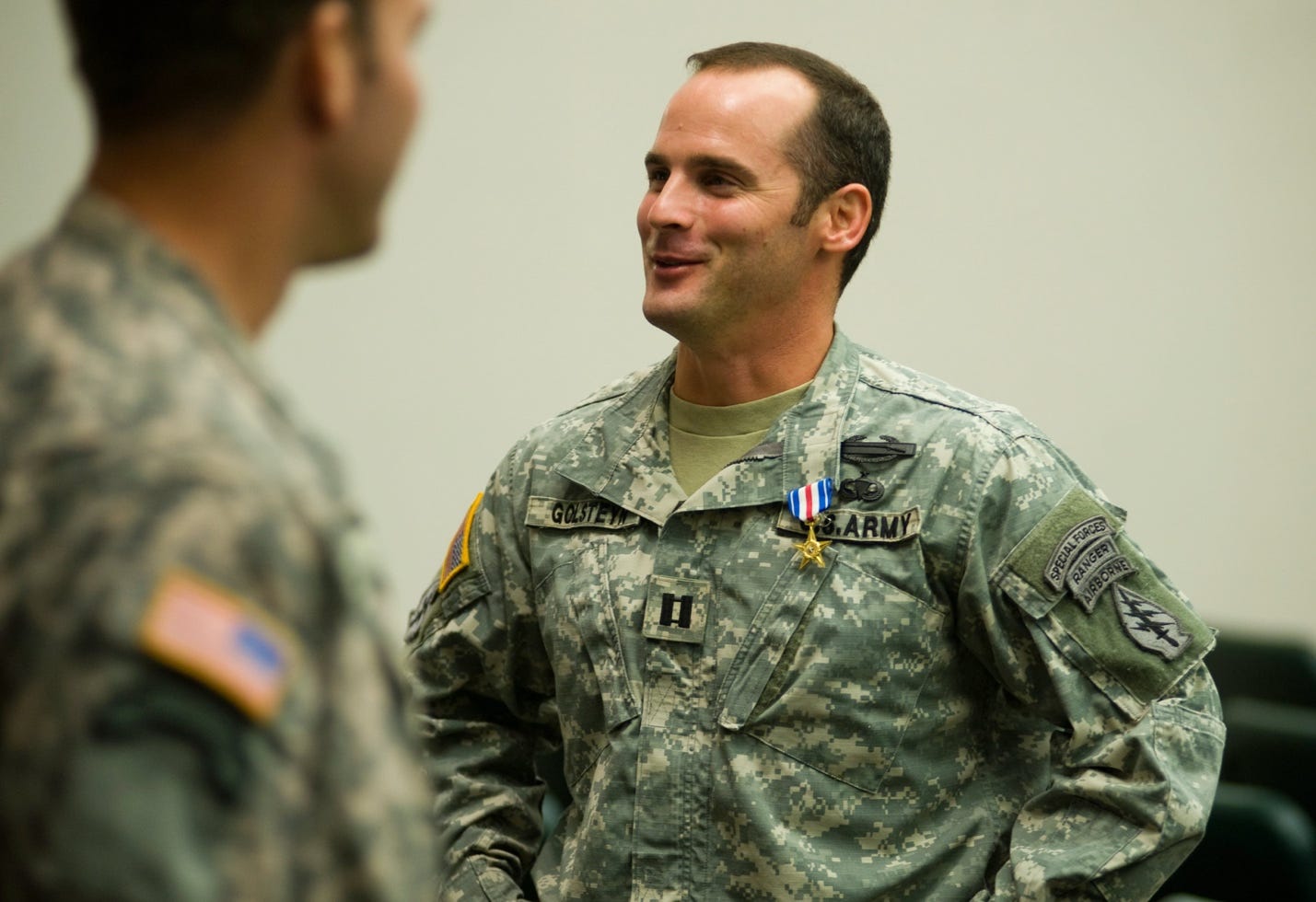 A person in military uniform talking to another person

AI-generated content may be incorrect.