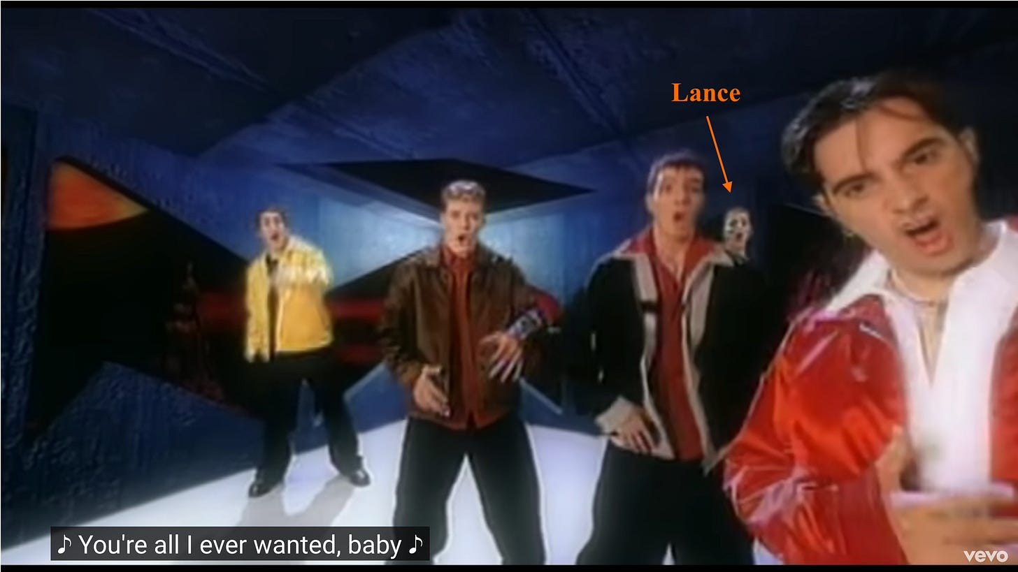 The guys are angled again and Lance is once more in the background. An orange arrow and the word Lance point out his tiny head in back.