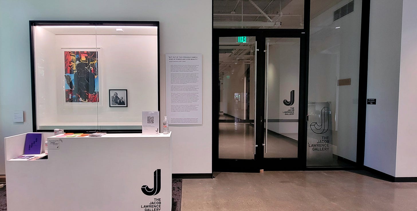 Reception area with white desk and glass doors to the galleries.