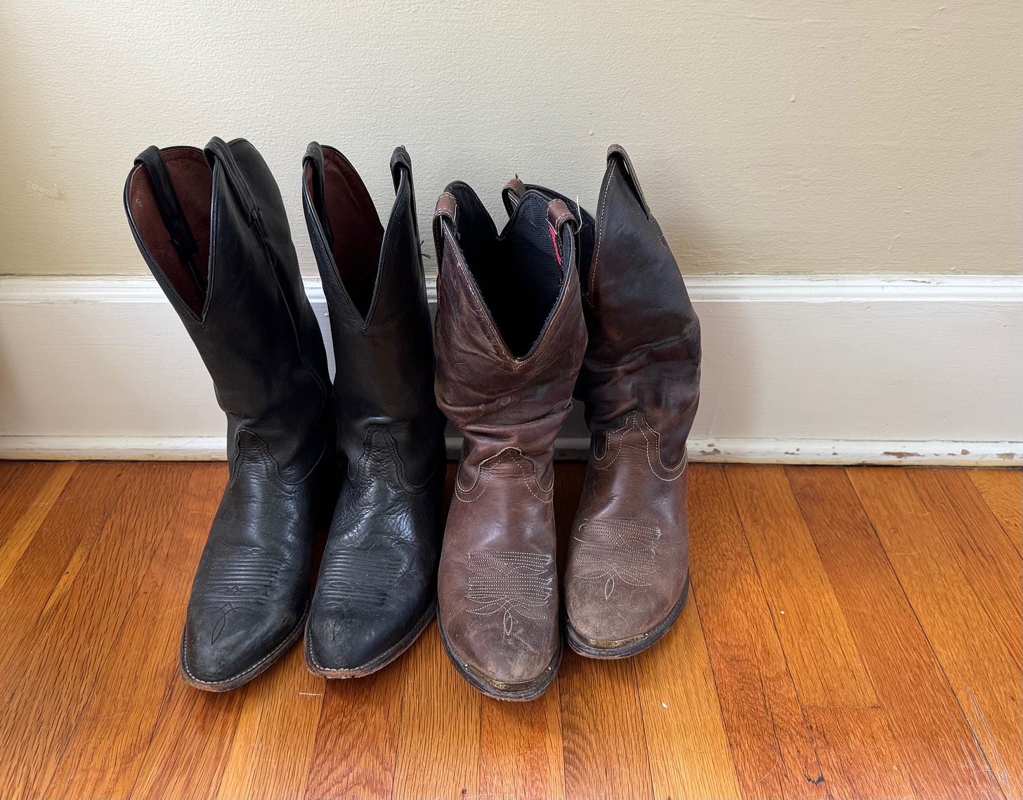 Two pairs of worn cowboy boots.