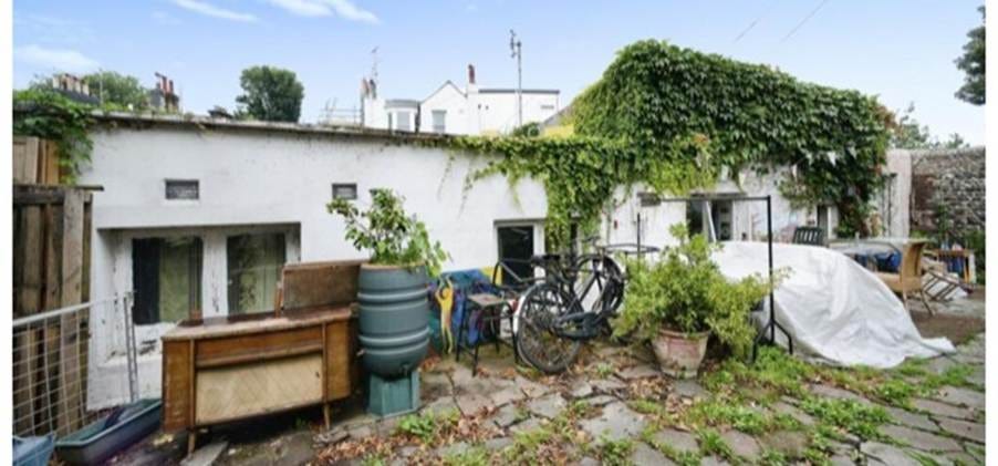 A white house with a bike and plants

AI-generated content may be incorrect.