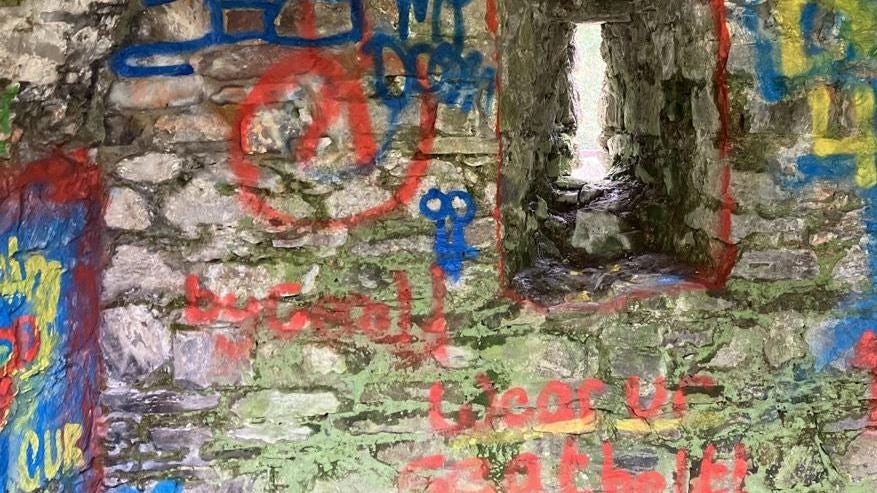 Multi-coloured graffiti painted on and covering most of the medieval masonry of the under croft at St Davids Bishop's Palace in Pembrokeshire.