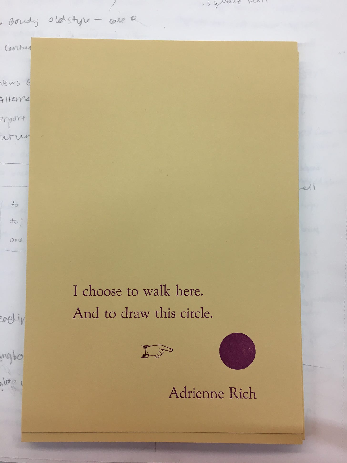 Print on yellow cardstock in purple ink with the quotation "I choose to walk here. And to draw this circle." by Adrienne Rich. There is a small outlined hand pointing to a filled-in circle.