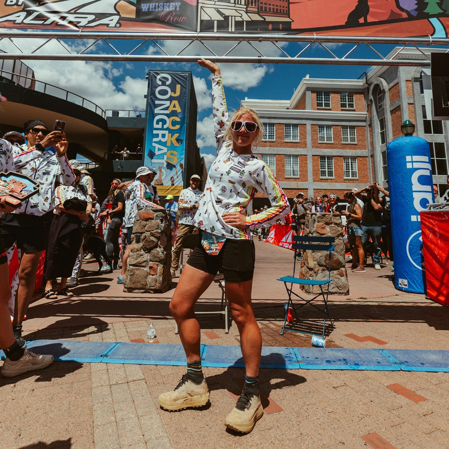 Participant posed under a promotional banner at an outdoor event.