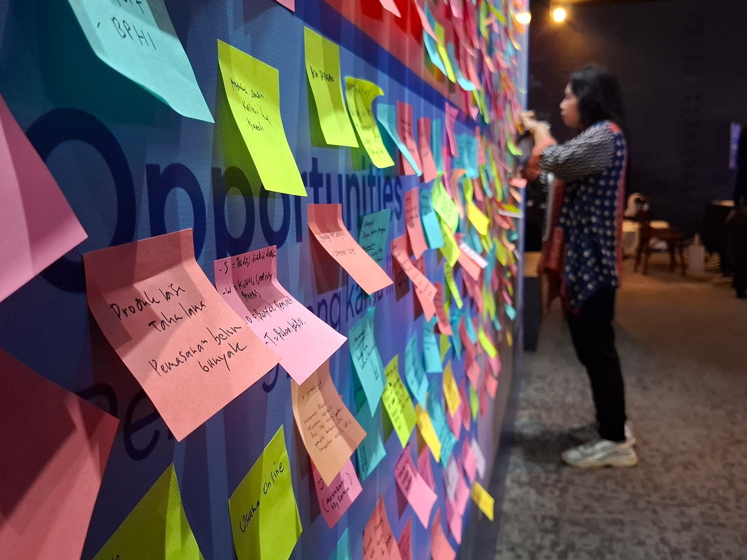 Women MSME owners participating in the UMKM Pintar launch event in Jakarta, with financial training booths and digital learning materials displayed.