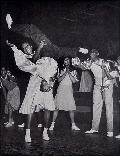 This may contain: black and white photograph of people dancing on stage