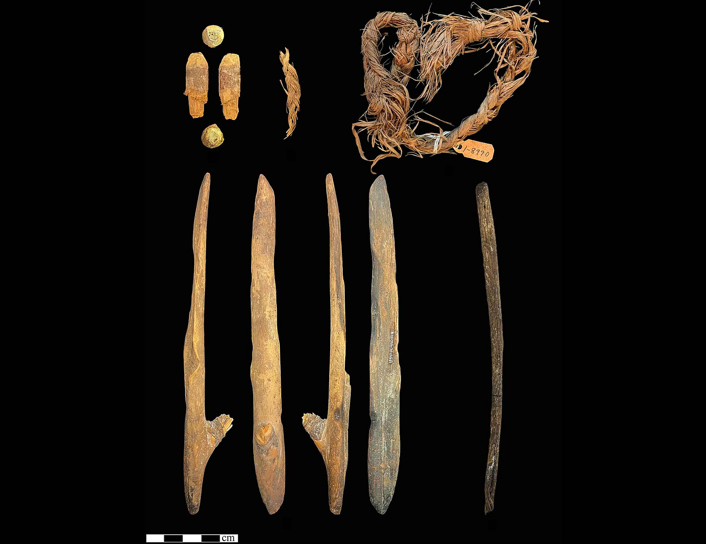 Five objects, three wooden objects, one larger with a stem on the side, one piece of cordage Five objects, three wooden objects, one larger with a stem on the side, one piece of cordage