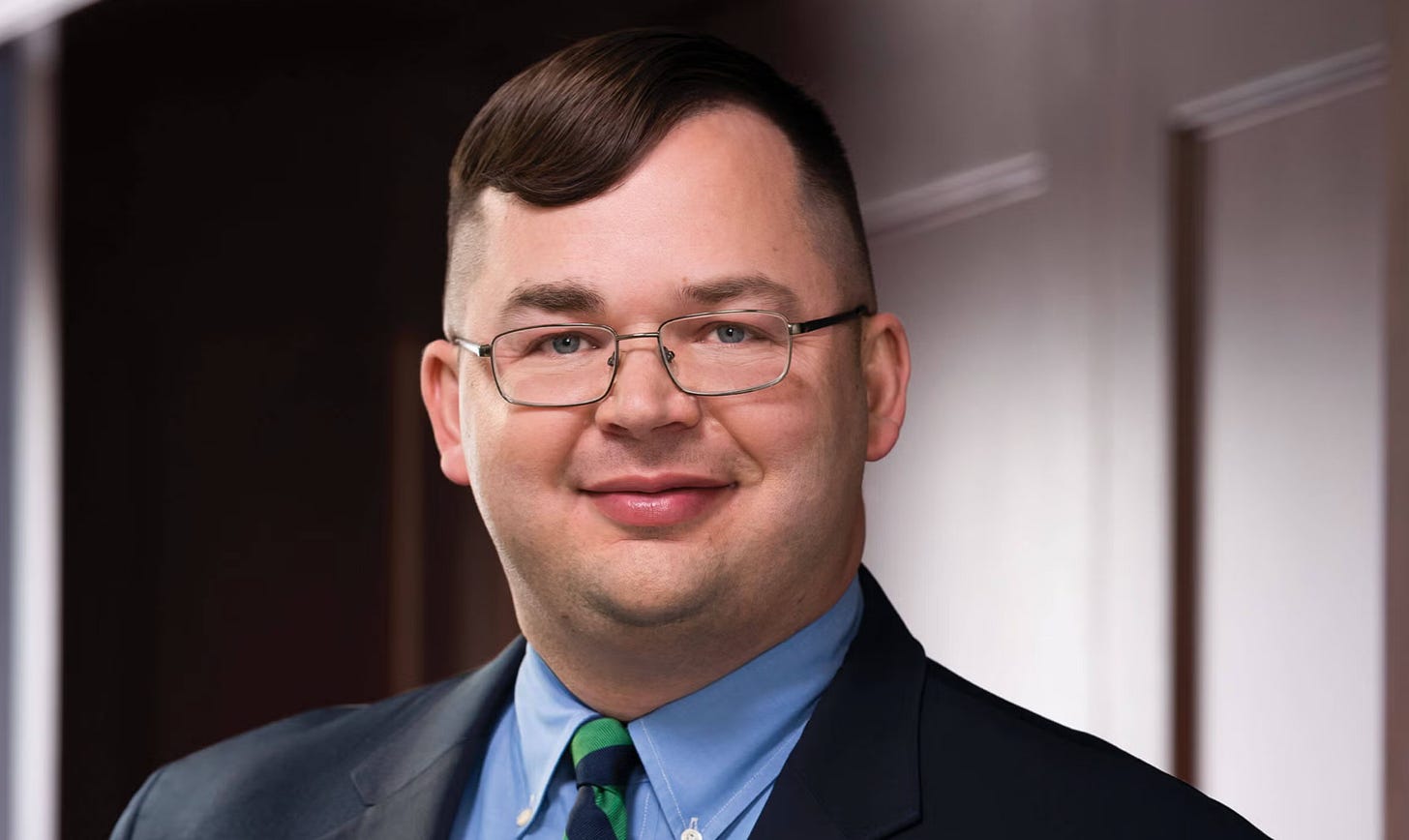 Jamie Bryan Hall, a brown-haired man who looks a lot like francis from Pee-Wee's Big Adventure but with strange bangs that swirl around his head. I'm sorry, they are not easy to describe.