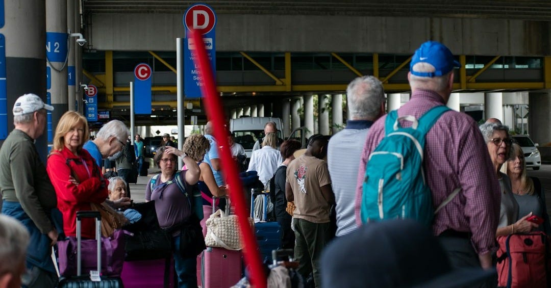 A group of people standing around with luggage A group of people standing around with luggage