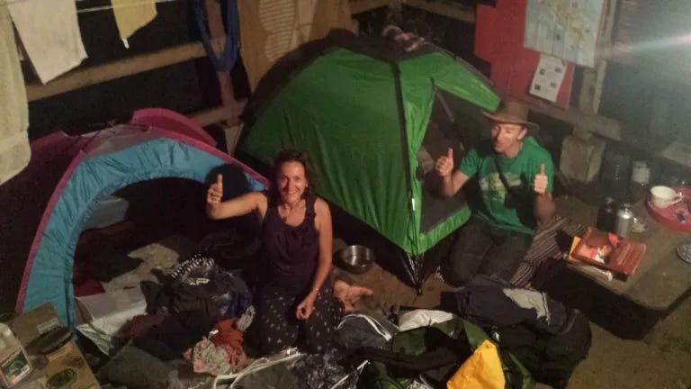 A person and person sitting in a tent

Description automatically generated