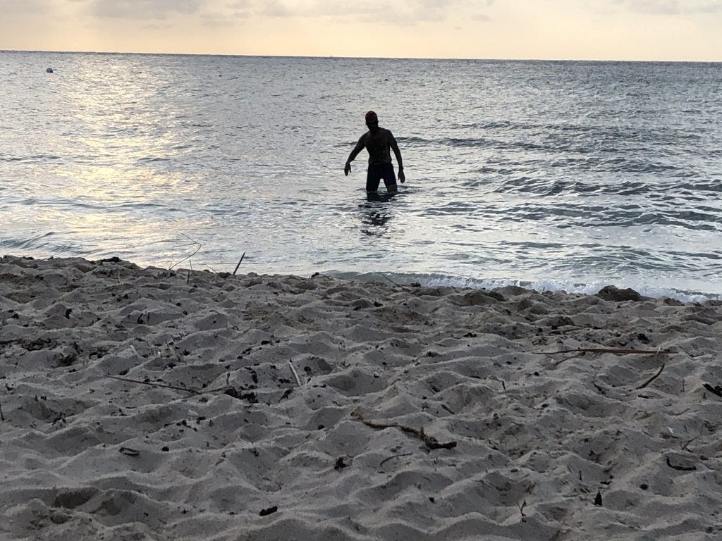 The silhouette of a man walking into the ocean at sunset for a swim. The silhouette of a man walking into the ocean at sunset for a swim.