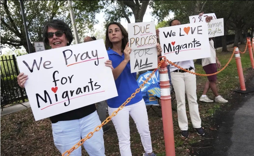 Several people holding signs in front of a fence

AI-generated content may be incorrect.