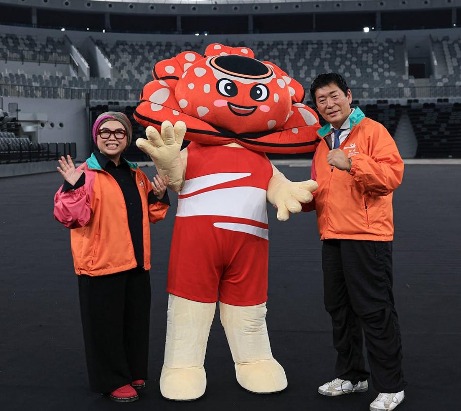 Indonesian Gymnastics Federation Chairwoman Ita Yuliati (left) and FIG President Morinari Watanabe flank Nodi, the mascot, which symbolizes the harmony between strength and beauty.
