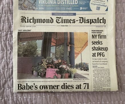 front page newspaper with photo of flowers and signs piled by front door of bar