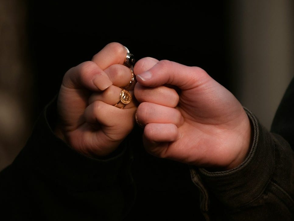 person holding gold ring in dark room person holding gold ring in dark room