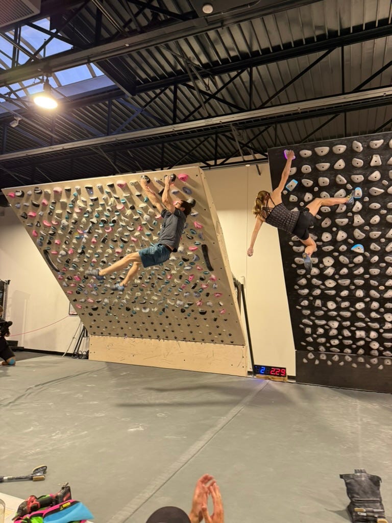 Two climbers sending problems on side-by-side boards. Two climbers sending problems on side-by-side boards.