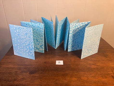 folded paper fanned out in various shades of blue.