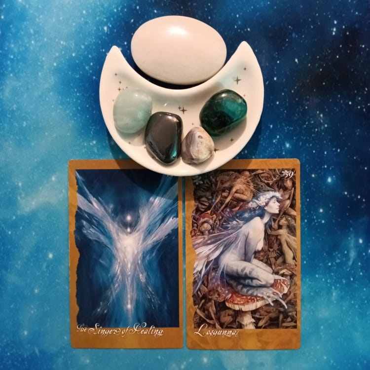2 Faeries Oracle cards and crystals on a starry blue background 2 Faeries Oracle cards and crystals on a starry blue background