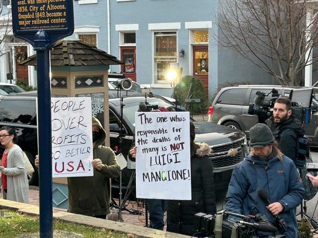 A handful of protestors carried signs criticizing the health insurance industry at the extradition hearing of Luigi Mangione, the suspected killer of United Healthcare CEO Brian Thompson, at Blair County Courthouse in Holidaysburg, Pennsylvania. (Todd Karpovich/Staff)