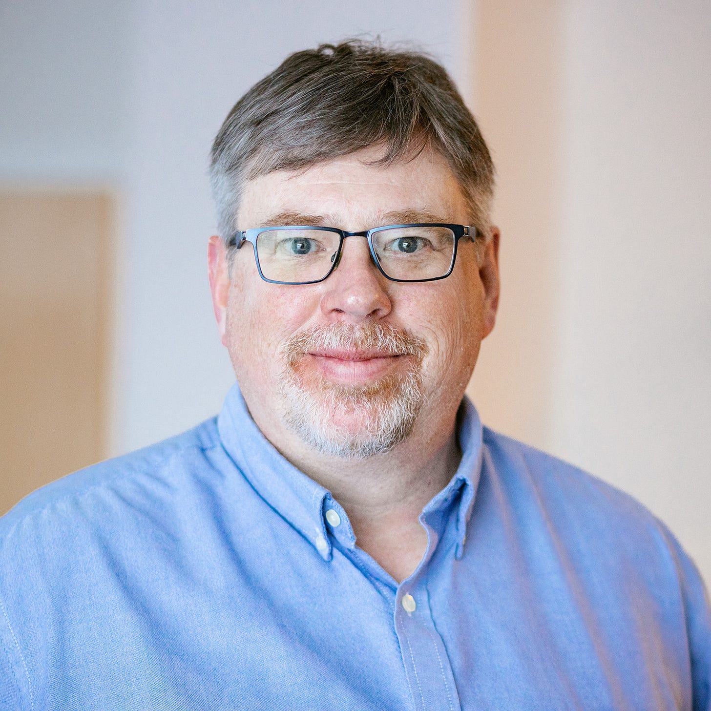 Image of Michael Mason wearing glasses and a blue shirt