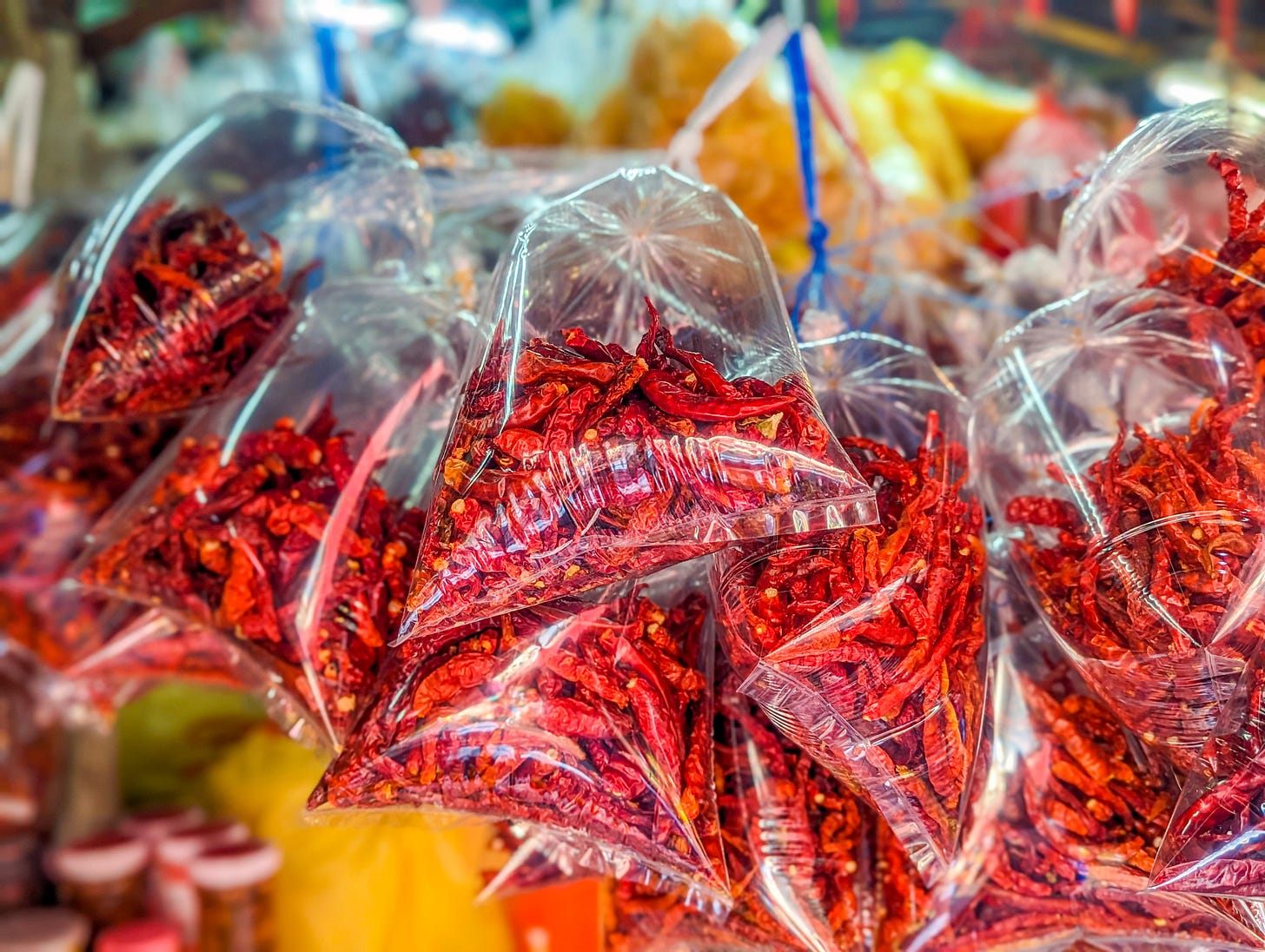 Plastic bags filled with bright red peppers. 