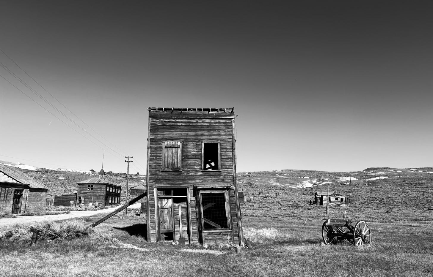 ramshackle ghost town building with wagon and other buildings