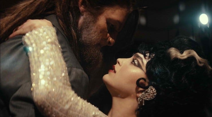 A woman dressed as the bride of Frankenstein is dancing with a beastly looking character