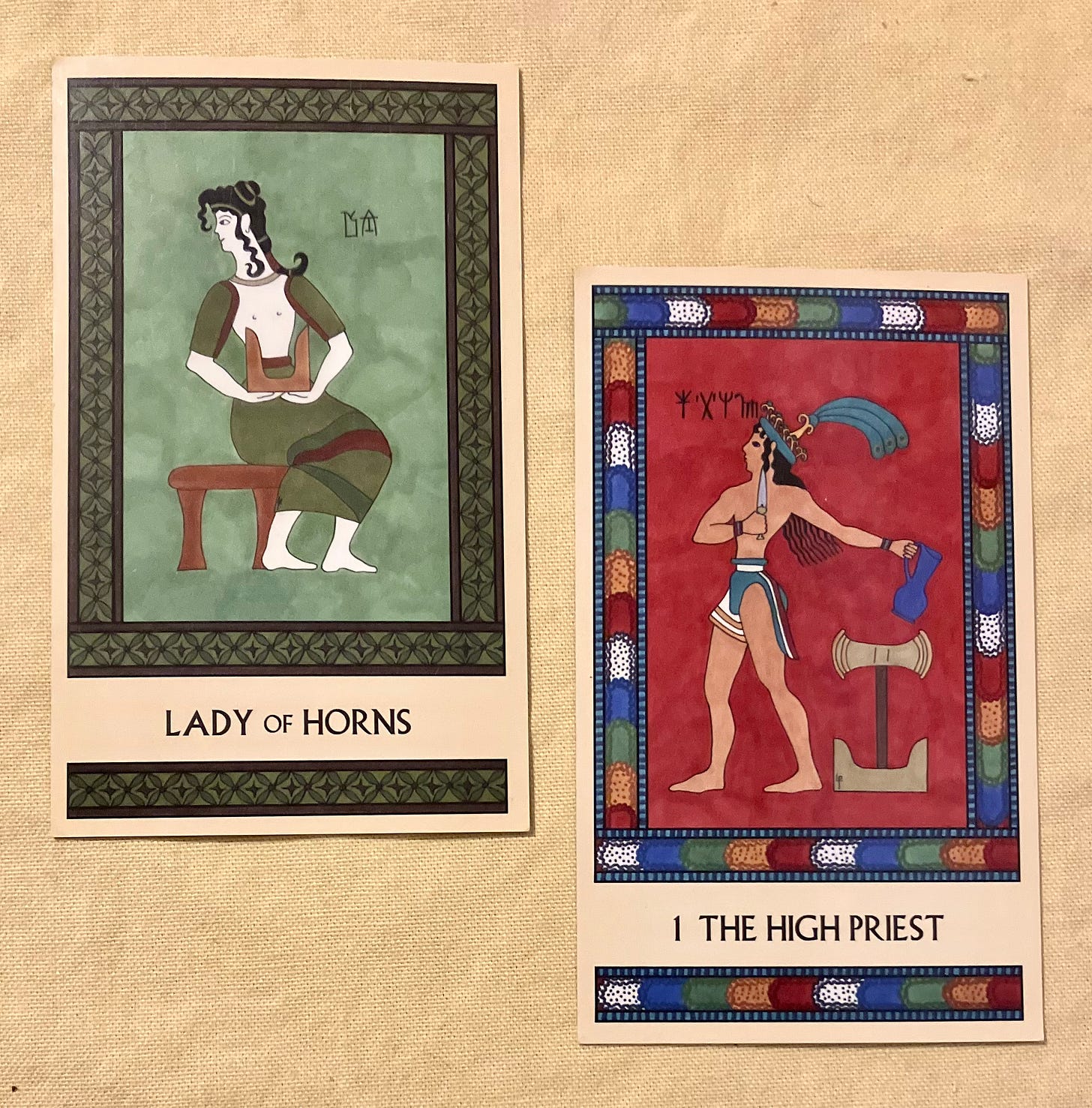 Two Minoan Tarot cards side by side on a pale yellow background. The Lady of Horns is painted in shades of green and brown. A Minoan woman sits on a stool, facing right but with her head turned back toward the left. She holds a pair of sacred horns in her lap. The High Priest has a bright multicolored border. It shows a Minoan man in a loincloth and a plumed hat, standing, facing left. He holds a dagger in his right hand and a pitcher in his left hand. Next to him stands a pair of sacred horns with a labrys mounted atop them. 