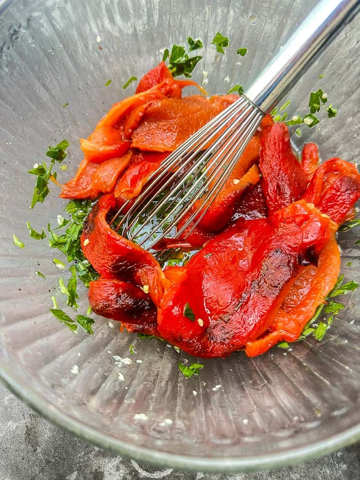 Sweet roasted red peppers marinated with garlic, herbs, and olive oil. An easy make-ahead recipe for sandwiches, salads, and snack boards. Full recipe on Shutterbean. Sweet roasted red peppers marinated with garlic, herbs, and olive oil. An easy make-ahead recipe for sandwiches, salads, and snack boards. Full recipe on Shutterbean.