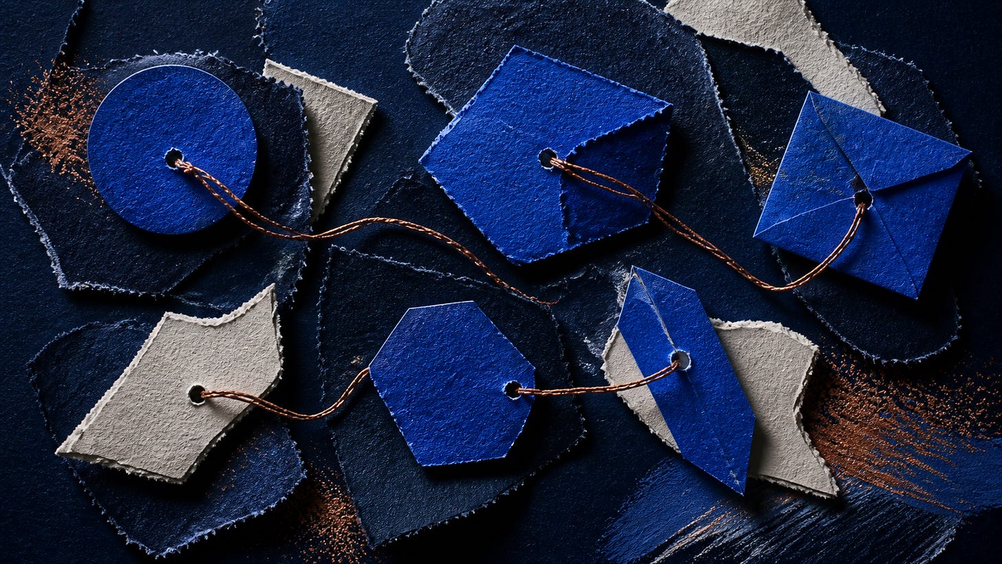 Blue and beige textured paper tags connected by brown strings, arranged together.