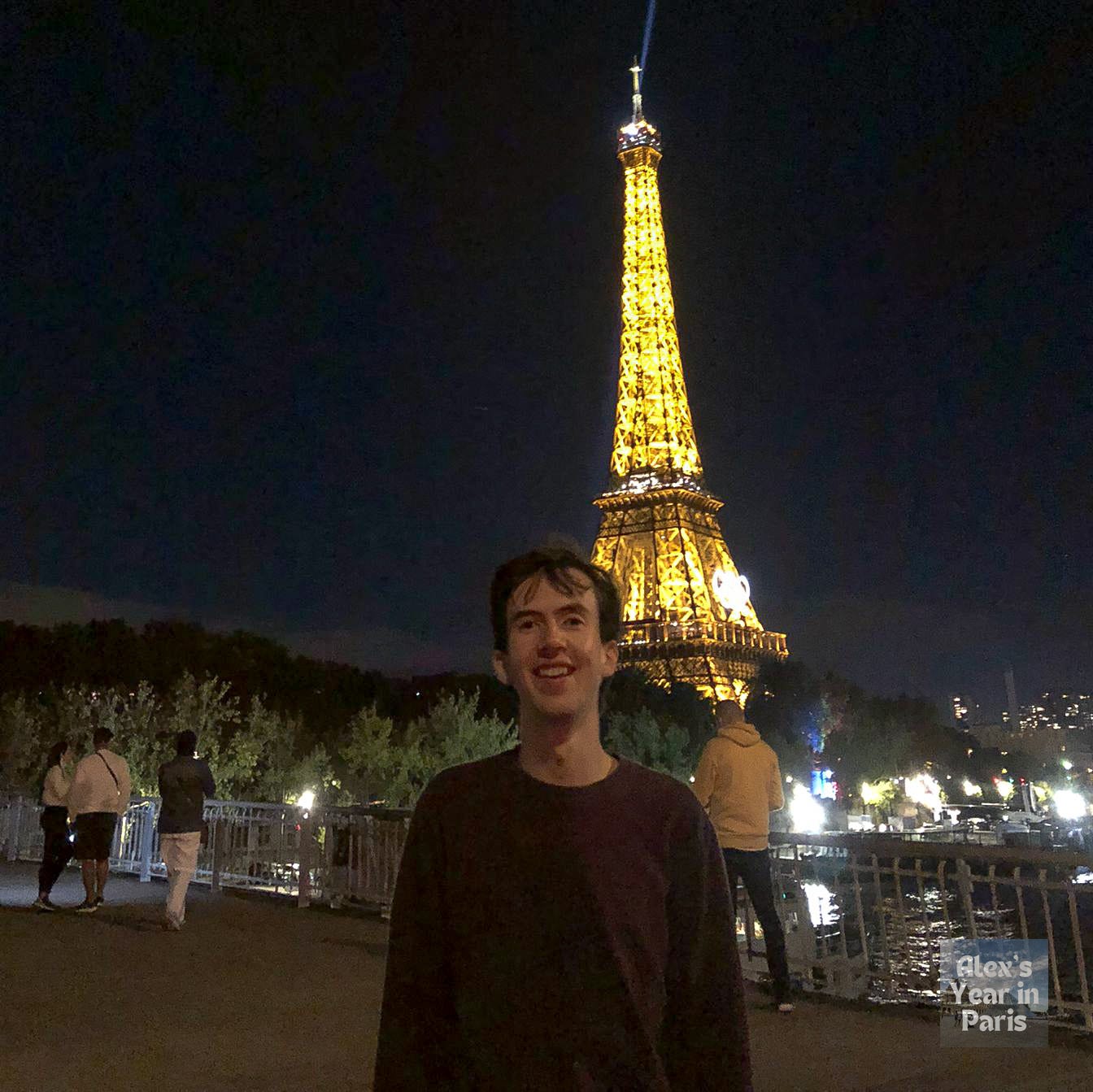 Me posing in front of the Eiffel Tower at night