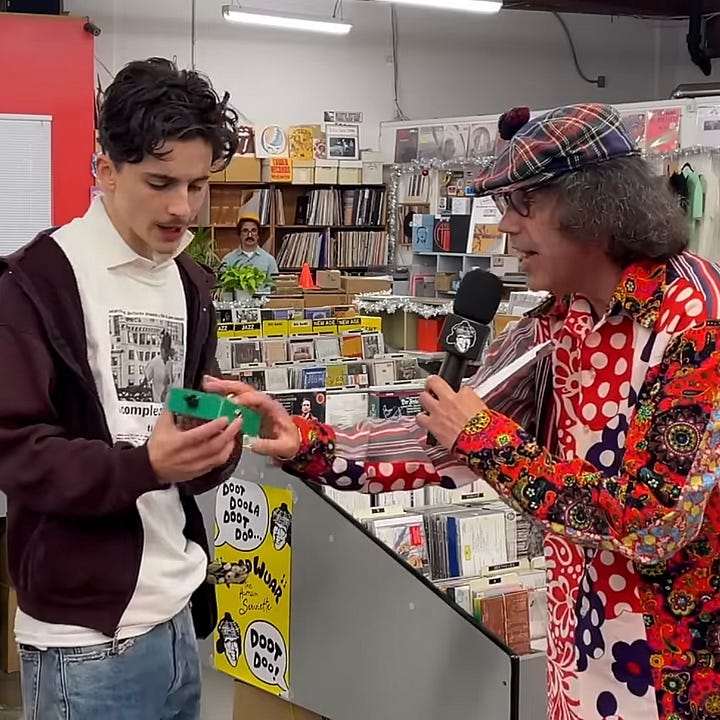 Nardwuar offre à Timothée Chalamet une pédale de guitare à leur effigie.