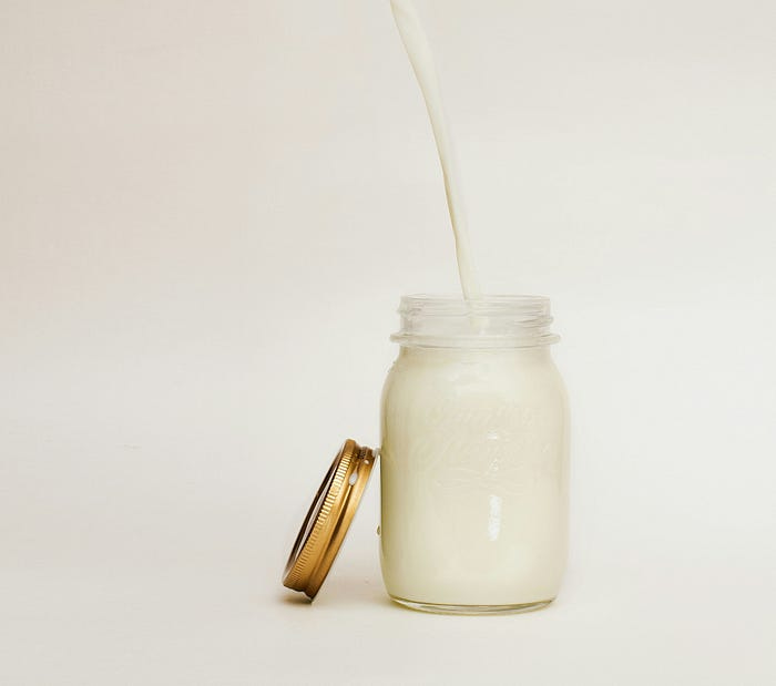 Pouring milk into a mason jar. Raw milk is a potential vector for many serious diseases.