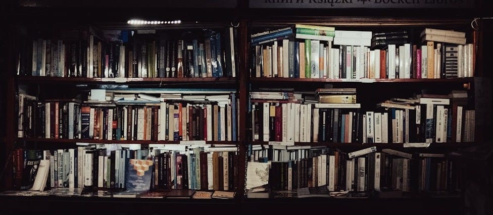 a bookshelf filled with lots of books in a dark room