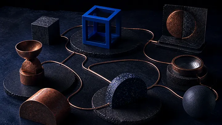 Dark tabletop arrangement of connected copper lines and geometric forms, centred on a blue open cube