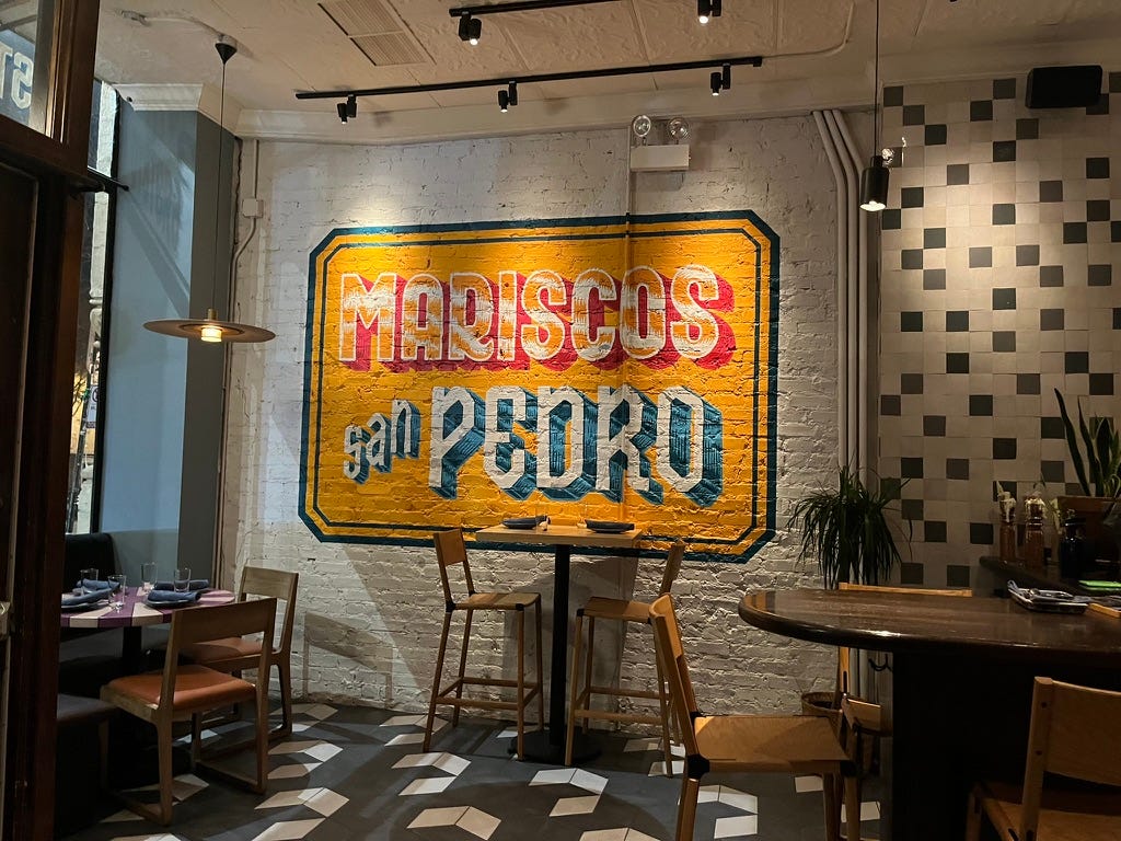 Mural saying "MARISCOS SAN PEDRO" on the wall of a restaurant