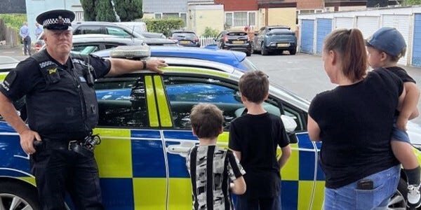 Officer and a family next to a police car