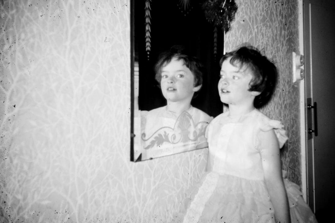girl wearing beige dress standing in front of mirror girl wearing beige dress standing in front of mirror