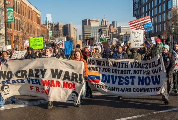 People march along Michigan Avenue near Trumbull Street after gathering to protest at the MotorCity Casino Hotel in Detroit during a visit from President Donald Trump as he speaks with the Detroit Economic Club on Tuesday, Jan. 13, 2026.